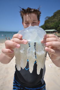 Midsection of man holding blue sea