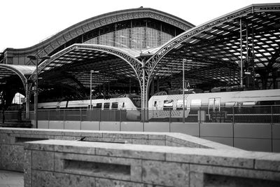 Train at railroad station in city against sky