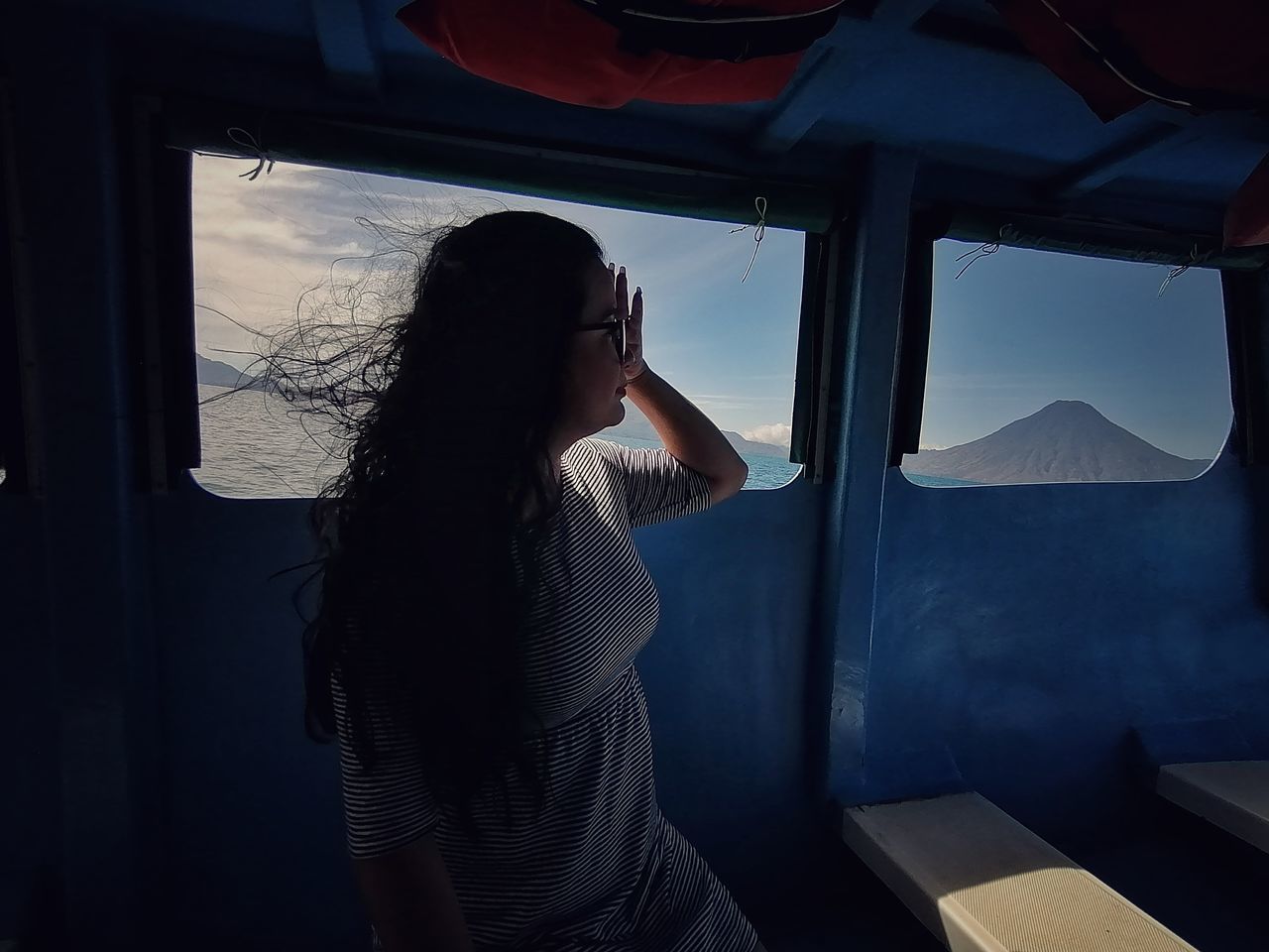 one person, adult, window, women, blue, transportation, mode of transportation, indoors, long hair, looking, young adult, travel, hairstyle, nature, side view, darkness, lifestyles, waist up, black, light, looking through window, vehicle, casual clothing, sky, three quarter length, vehicle interior, contemplation, screenshot, journey