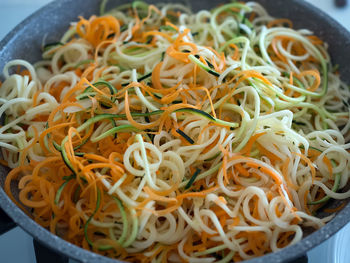 Close-up of noodles in bowl on gas stove burner