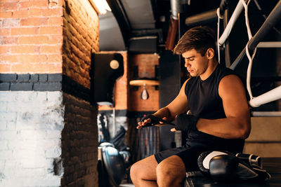 Young man sitting on wall