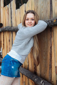 Young beautiful girl near wooden fence