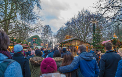 Rear view of people on street against sky