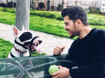 Young man with dog sitting on bench