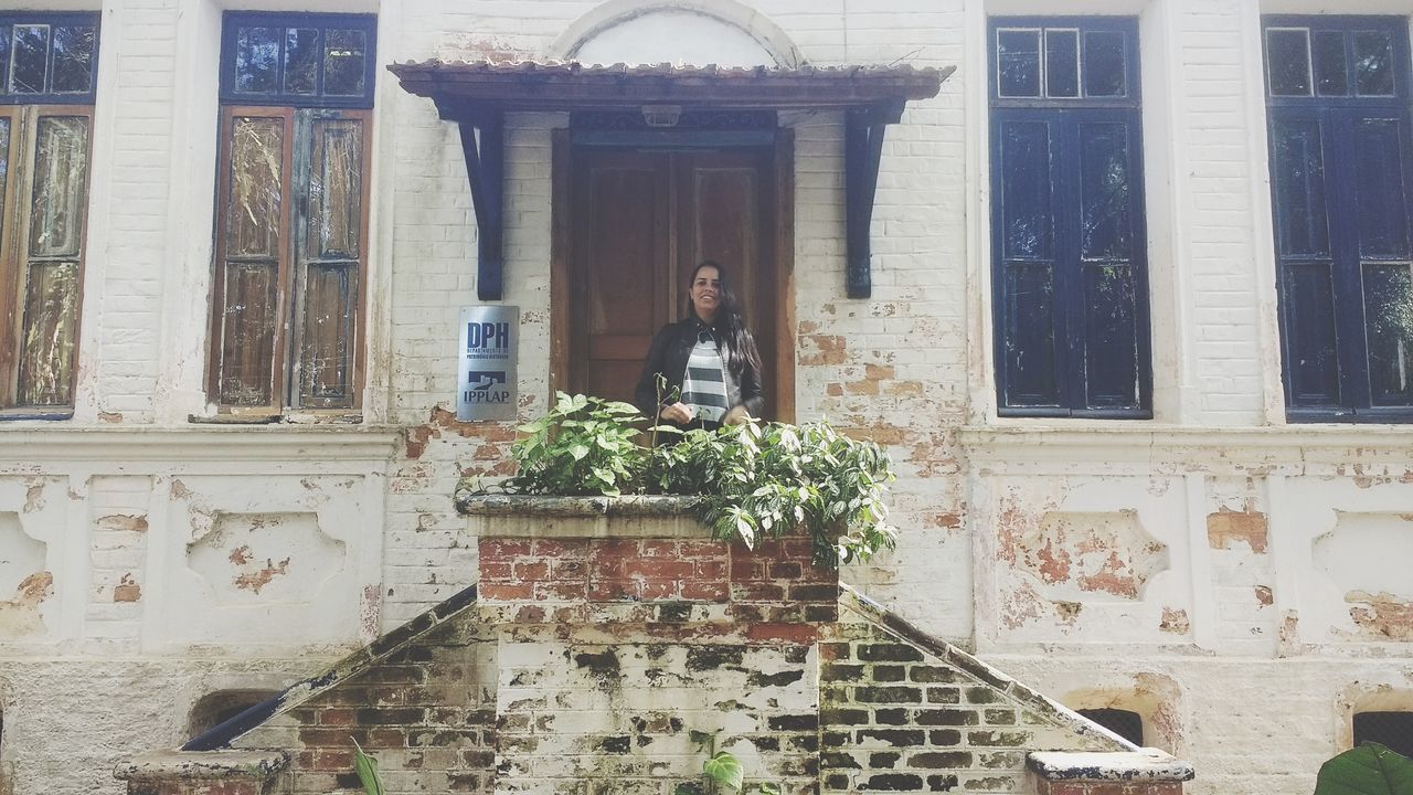 WOMAN STANDING BY WINDOW