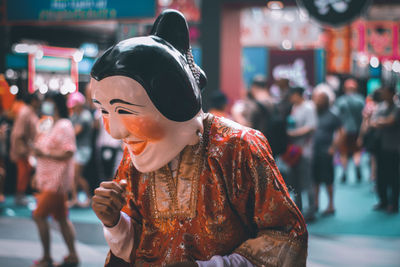 Woman wearing mask standing on street in city