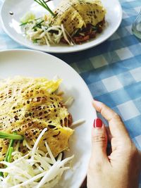 Close-up of hand holding bowl of food