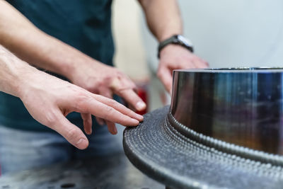 Male engineers touching machinery at factory