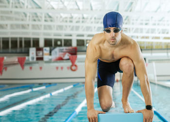 Portrait of shirtless man exercising in gym