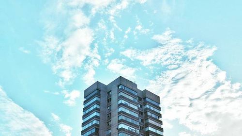Low angle view of building against cloudy sky