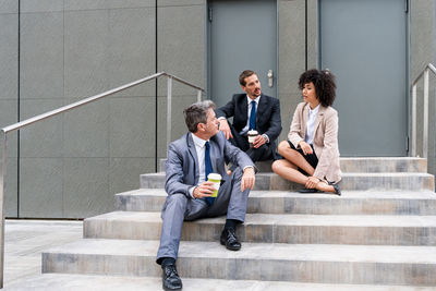 Low angle view of business people sitting on steps