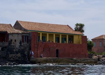Houses by river against sky