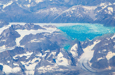 Aerial view of snowcapped mountains by sea