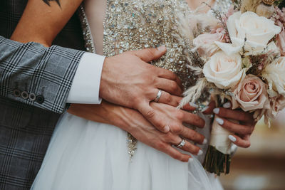 Wedding couple holding hands and putting ring close up