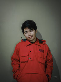 Portrait of young man standing against wall