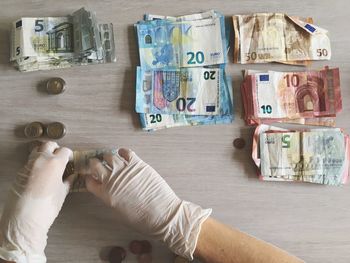 Cropped image of hands arranging currencies on table