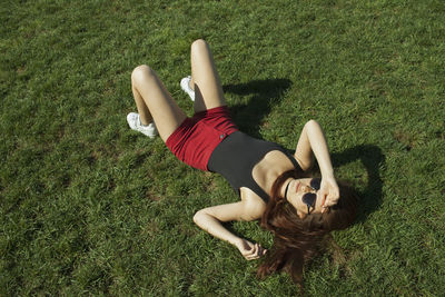 A young woman lying down on grass