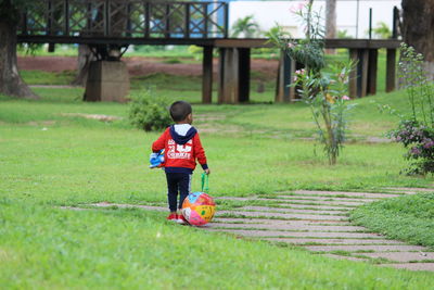 Rear view of boy playing on field