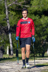 Nordic walking. young person practicing the sport nordic walking with poles in an outdoor park