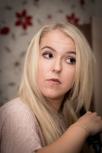 Beautiful woman combing hair at home