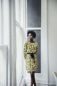 Thoughtful businesswoman looking through window in creative office