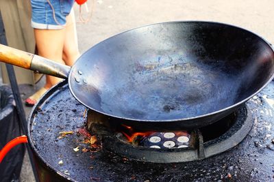 Close-up of person preparing food on barbecue grill