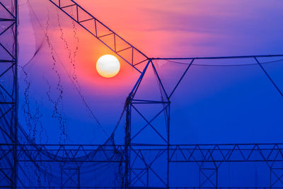 Low angle view of illuminated lamp against sky at sunset