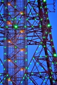 Illuminated television tower against blue sky