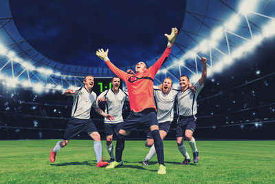 Men celebrating soccer on field