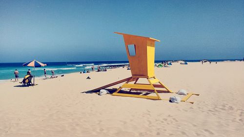 Lifeguard hut at beach against clear blue sky