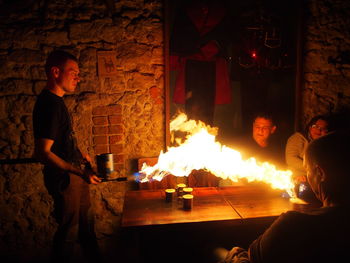 Side view of man holding lit candles at night