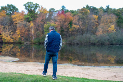 Rear view of man walking by lake