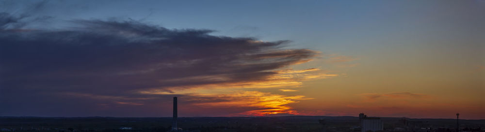 Low angle view of building against dramatic sky during sunset