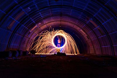People walking in illuminated tunnel