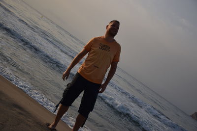 Man standing on beach against sky