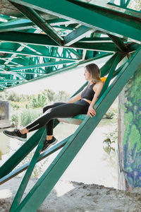 Side view of woman sitting at playground