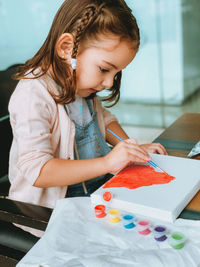 Full length of little girl painting 
