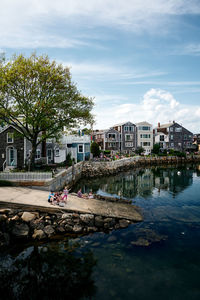 Scenic view of river by buildings against sky