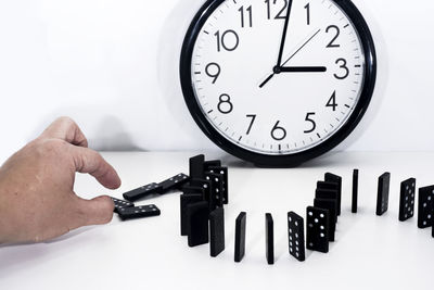 Midsection of person holding clock against white background