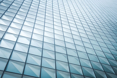 Low angle view of glass building against sky