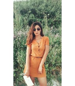 Portrait of beautiful young woman standing against plants