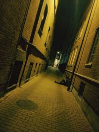 Alley amidst buildings in city at night