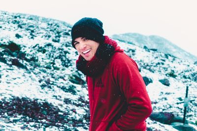 Portrait of smiling young woman standing in snow