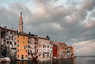 View of buildings in city against cloudy sky