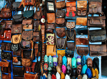 Bags and shoes hanging at market for sale