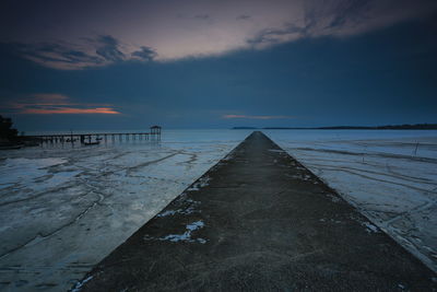 Pier over sea against sky during sunset