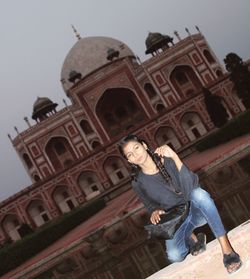 Low angle view of young man standing against building