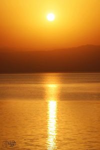 Scenic view of sea against orange sky