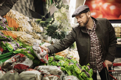 Man buying fresh vegetables in supermarket