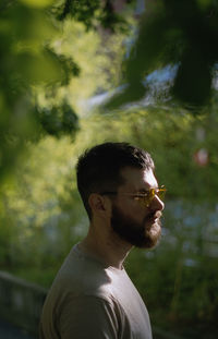 A side view of a man wearing sunglasses on a sunny day